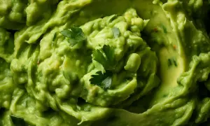 Gęsta, kremowa pasta z awokado, ozdobiona listkami świeżej kolendry. Idealna do nachos lub jako dodatek do kanapek.