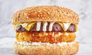 Apetyczny burger drwala przepis: soczysta wołowina, chrupiąca panierka, ser i biały sos na sezamowej bułce.
