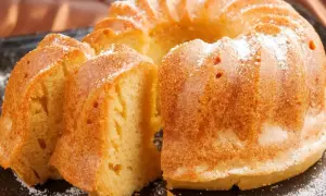 Puszysta babka wielkanocna, oprószona cukrem pudrem, kusi swoim złotym kolorem i delikatnym wnętrzem. Idealna na świąteczny stół.