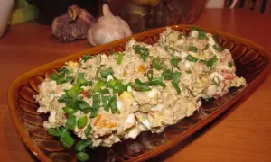 Pyszna pasta z sardynek z jajkiem i szczypiorkiem, podana na brązowym talerzu.