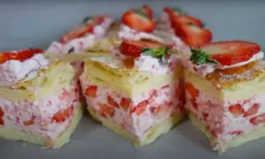 Pyszne ciasto francuskie z truskawkami i kremem, udekorowane świeżymi owocami. Idealne na deser.