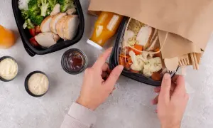Dwa pudełka z jedzeniem na wynos: kurczak z ryżem i warzywami, sosy, sok. Idealny lunch co to?