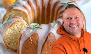 Uśmiechnięty mężczyzna obok pysznej babki majonezowej z lukrem i rozmarynem.