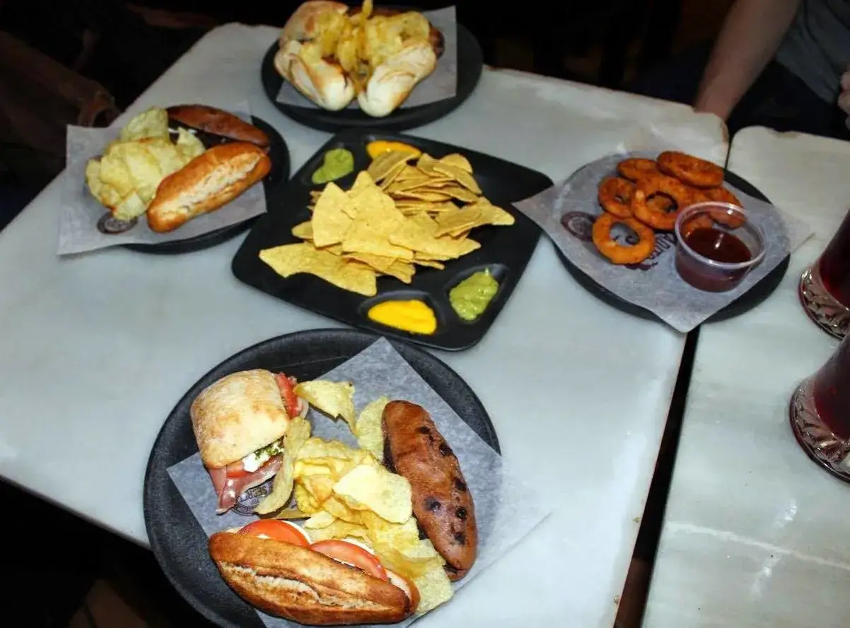 Pyszne hiszpańskie tapas kanapeczki, nachos z dipami, krążki cebulowe i frytki na stole.