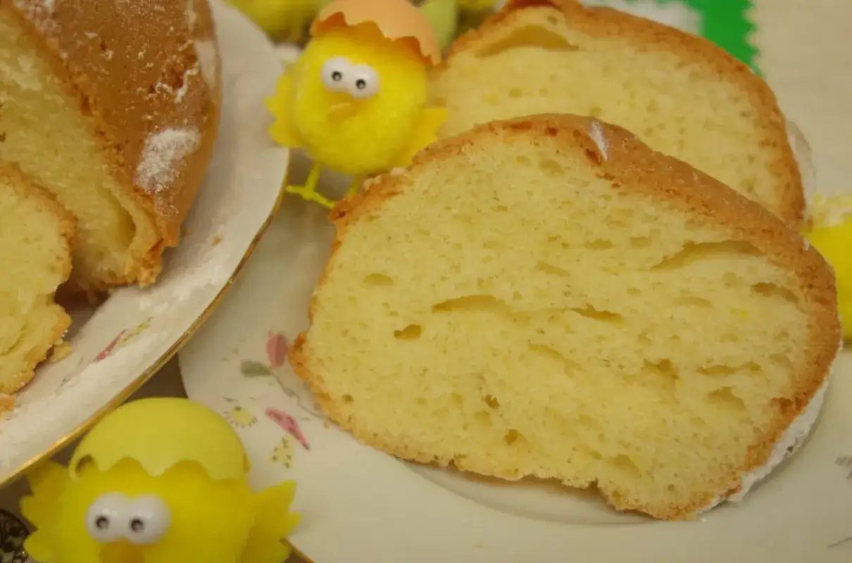 Puszysta babka majonezowa, pokrojona w plastry, z ozdobnymi kurczaczkami wielkanocnymi.