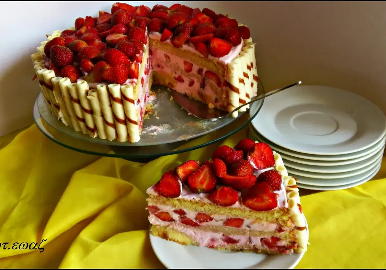Pyszny tort truskawkowy, udekorowany świeżymi owocami i wafelkami, kusi swoim wyglądem.