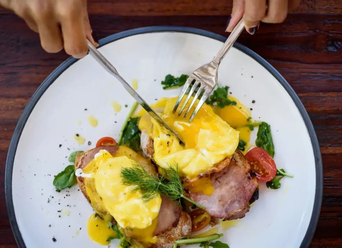 Pyszne jajka po benedyktyńsku z holenderskim sosem, szynką i pomidorkami na chrupiącej grzance. Idealne na brunch!