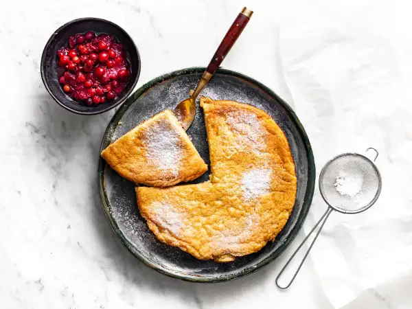 Puszysty omlet z cukrem pudrem i żurawiną. Idealny pomysł, jak zrobić omlet na śniadanie.