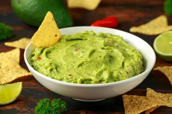 Pyszne guacamole przepis na domową przekąskę. Kremowe awokado, świeża limonka i chrupiące nachos.